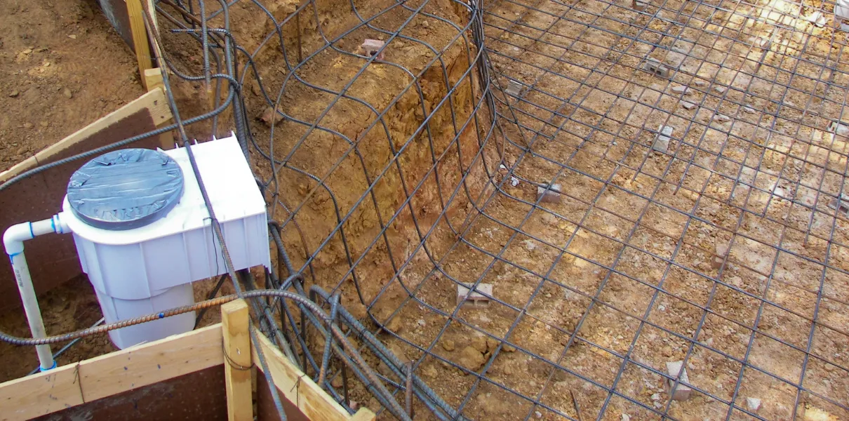 A wide, sunlit view of an older backyard swimming pool in Los Angeles, showing wear on the plaster, tile line, and some remaining green water, ready for a complete remodeling and renovation.