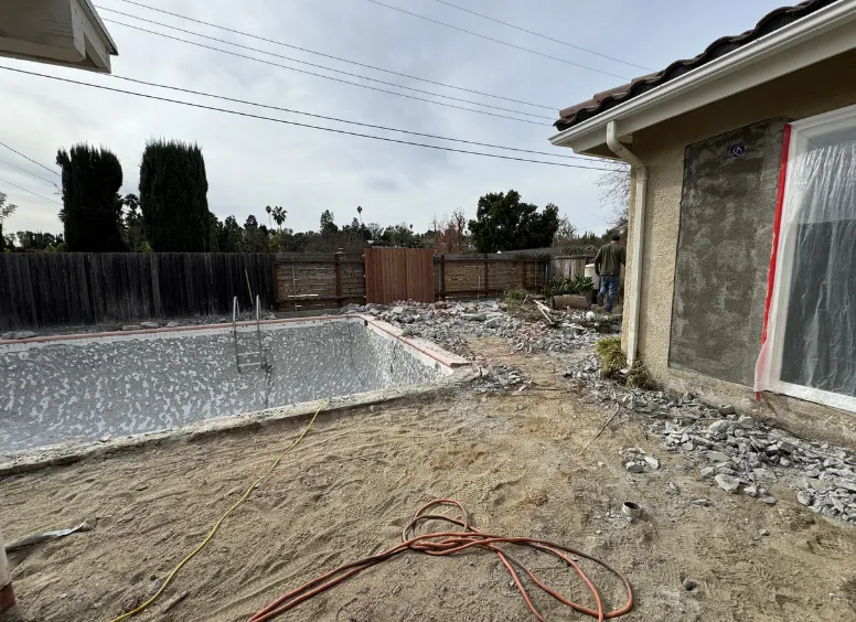 A close-up of a sparkling blue tiled pool with stainless steel ladders, showcasing the high-quality results of Pools Los Angeles professional maintenance.
