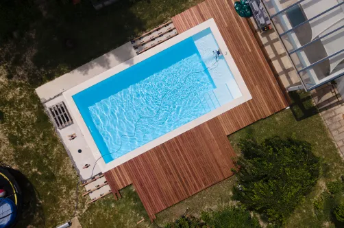 New custom pool with premium blue tile finish being filled for the first time after successful construction.