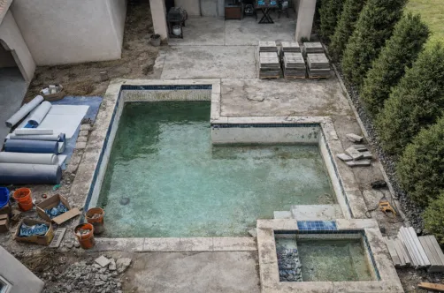 Certified technician installing energy-efficient pumps and smart automation systems during a luxury pool renovation.