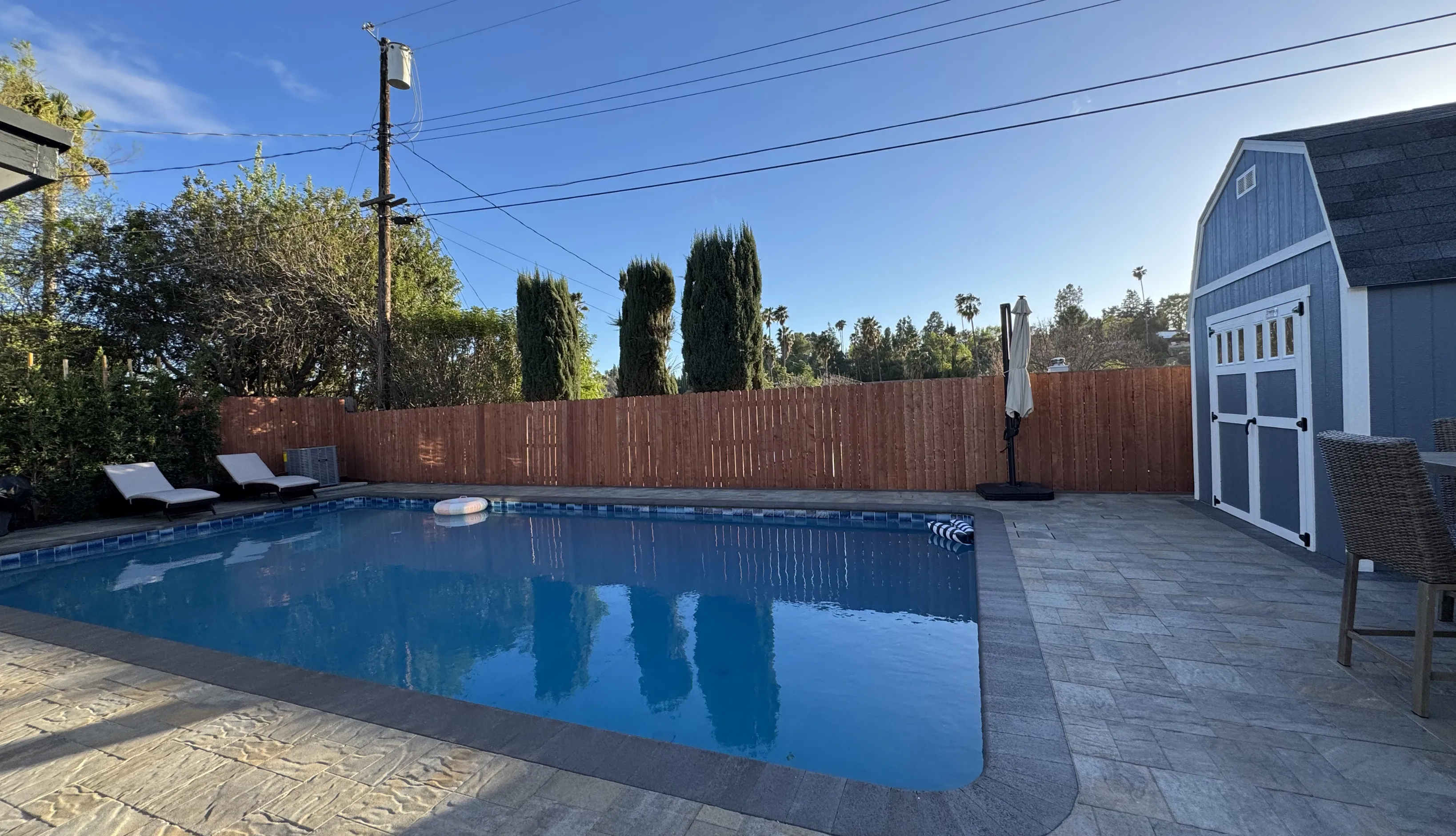 Contemporary blue tile lap pool design optimized for narrow backyard spaces in Southern California luxury homes